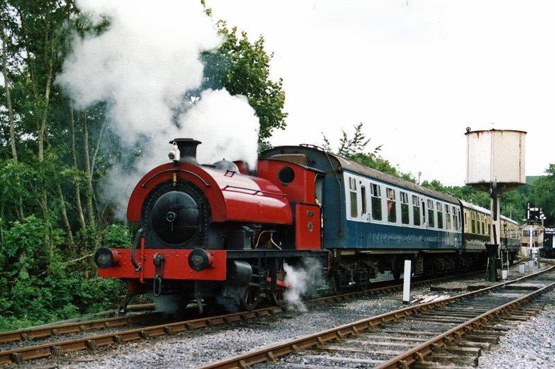 Olwen-Carriages a train on a track with smoke coming out of it