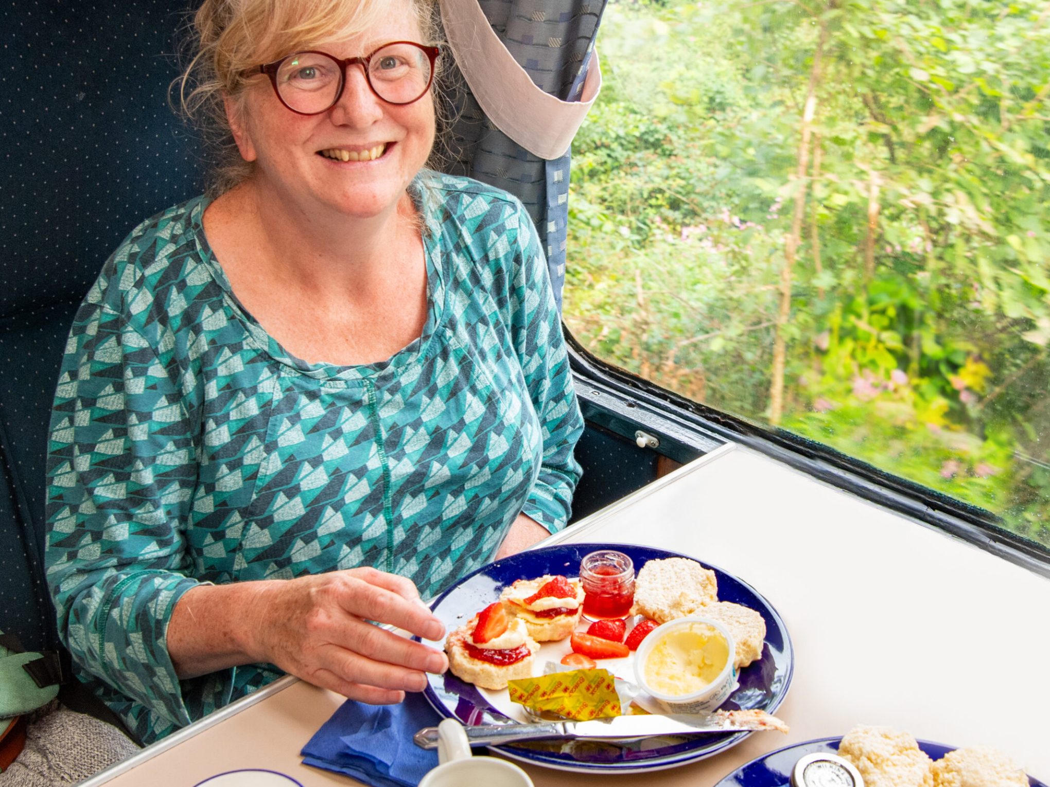a woman sitting at a table with a plate of food