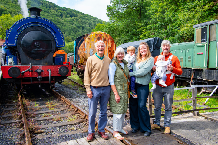 a group of people standing next to a train