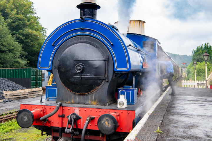 a steam engine is sitting on a train track
