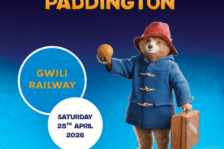 Paddington Bear in coat and hat with briefcase and orange, promoting event at Gwili Railway, April 25, 2026.